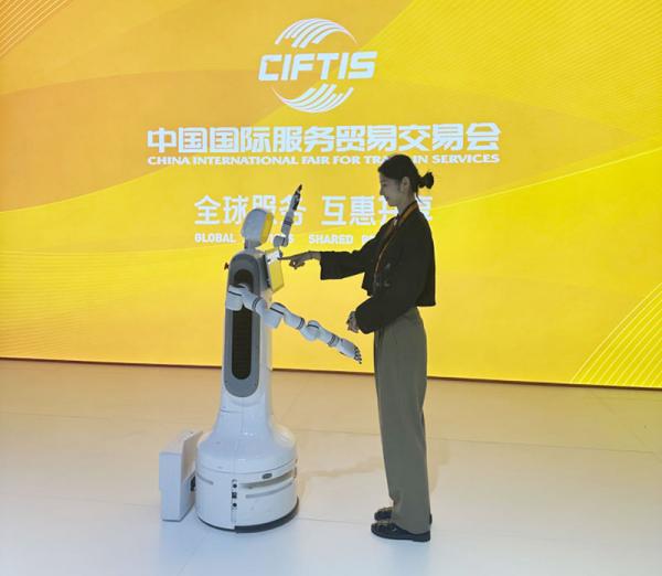 2024服贸会现场，一名观众和智能机器人互动。人民网记者 赵竹青摄